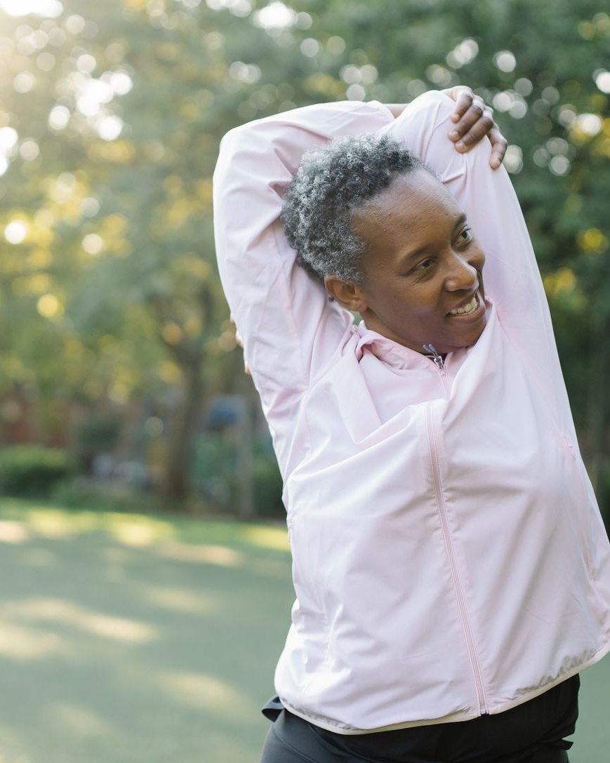 A woman stretching outdoors, staying strong and active through menopause